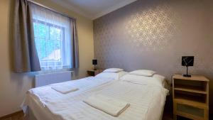 A bed or beds in a room at Őzkút Apartmanház