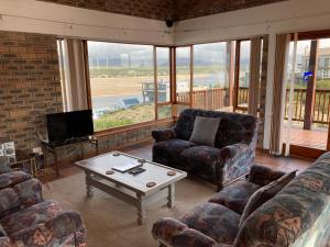 a living room with couches and a coffee table at Net Net Holiday Home in Witsand