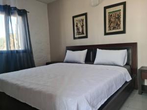 1 dormitorio con 1 cama con sábanas blancas y ventana en Splendide duplex à MDIQ avec vue panoramique en M'diq