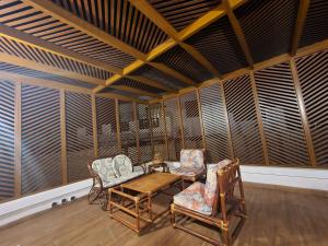 Habitación con sillas y mesa en una habitación con paredes de madera. en Splendide duplex à MDIQ avec vue panoramique en M'diq