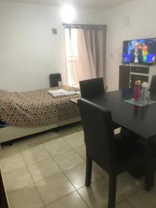 a room with a table and a bed and a television at Remedios de escalada Suite! Wifi Aire cable in Villa María
