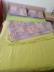 Una cama con sábanas amarillas y almohadas. en Apartman Monika Zlatar Nova Varos, en Nova Varoš