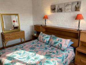 una camera da letto con un letto, un comò e uno specchio di Net Net Holiday Home a Witsand
