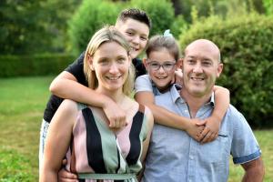 Un homme et une femme et deux enfants se serrent les bras. dans l'établissement Hotel Bel Sit, à Comano Terme