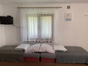 a bed with two pillows in front of a window at Eko Dolina Kluki in Kluki