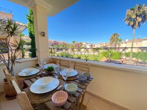 a dining table with a view of a balcony at Dúplex Amparo Altaona Golf in Murcia
