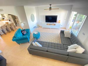 a living room with a gray couch and blue chairs at Dúplex Amparo Altaona Golf in Murcia