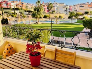 a balcony with a wooden bench and a potted plant at Magnífico-amplio Dúplex 2 plantas piscina Altaona in Murcia