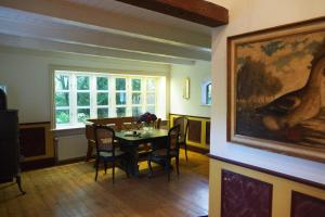 a dining room with a table and a painting on the wall at Ferien in einem historischen Bauernhaus mit Garten in Möhnsen