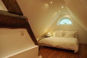 a bedroom with a white bed with a window at Ferien in einem historischen Bauernhaus mit Garten in Möhnsen
