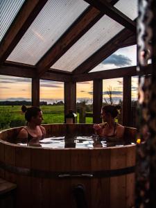 two women sitting in a hot tub with a view at Country Cottage with Spa, Catering, Gardens, Nature Reserve Walks - Free Parking, Self Checkin in Scunthorpe