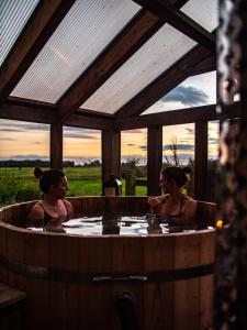 Dos mujeres sentadas en una bañera de hidromasaje con vistas en Country Cottage with Spa, Catering, Gardens, Nature Reserve Walks - Free Parking, Self Checkin, en Scunthorpe