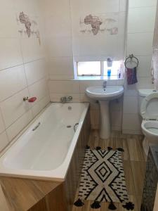 łazienka z wanną, umywalką i toaletą w obiekcie A Cozy one bed apartment in Pretoria Central w mieście Pretoria