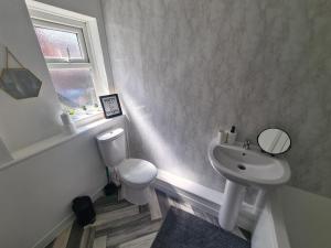 a white bathroom with a sink and a toilet at 5 bed sleeps 6, 2 miles (7 mins) from city centre in Low Team