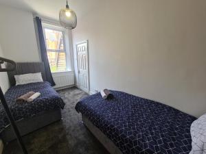 a bedroom with two beds and a window at 5 bed sleeps 6, 2 miles (7 mins) from city centre in Low Team