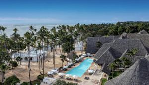 an aerial view of a resort with a pool and palm trees at Diamonds Mapenzi Beach - All Inclusive in Kiwengwa