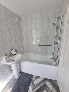 a bathroom with a tub and a sink and a shower at 5 bed sleeps 6, 2 miles (7 mins) from city centre in Low Team