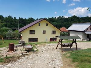a house with a picnic table and a playground at Viata la Tara Cerna in Cerna