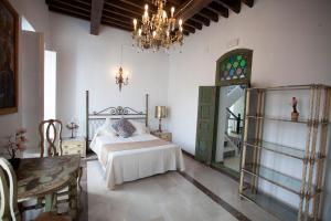 a bedroom with a bed and a chandelier at El Palacete de Cuevas in Cuevas del Almanzora