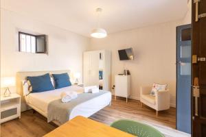 ein Schlafzimmer mit einem Bett und einem Stuhl in einem Zimmer in der Unterkunft Conde Central Courtyard by Valcambre in Sevilla