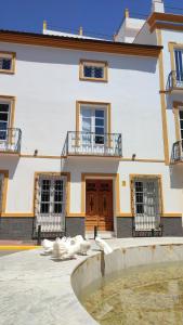 a large building with animals laying in front of it at El Palacete de Cuevas in Cuevas del Almanzora