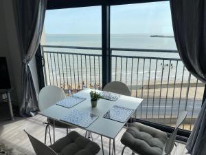 a table and chairs with a view of the beach at Penthouse Apartment with seaviews in Walton-on-the-Naze