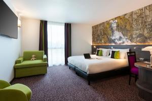 una camera d'albergo con un letto grande e una sedia di Hôtel Roi Soleil Prestige Plaisir - St Quentin a Plaisir Altre 29 foto