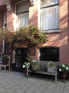 un bâtiment en briques avec deux bancs et des plantes en pot dans l'établissement Nine(T)Teen, à Amsterdam