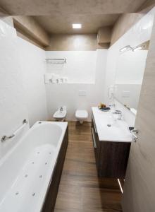 a bathroom with two sinks and a tub and a toilet at White Tower Mamaia Apartament Privat 503 in Mamaia