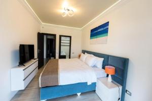 a bedroom with a large bed and a television at White Tower Mamaia Apartament Privat 503 in Mamaia