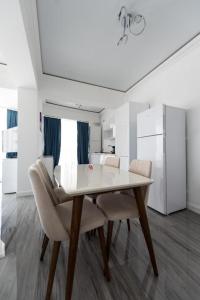 un comedor blanco con mesa y sillas en White Tower Mamaia Apartament Privat 503, en Mamaia