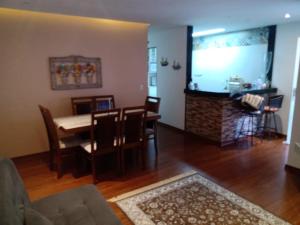 a dining room and living room with a table and chairs at Apartamento Angra dos Reis 1 in Angra dos Reis