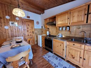 una cucina con armadi in legno, tavolo e lavandino di Peace and Lake Mountain Lake Iseo Hospitality a Bossico