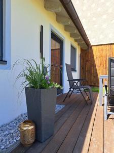 a wooden deck with a chair and a plant at Ferienwohnung Bauer in Böbing