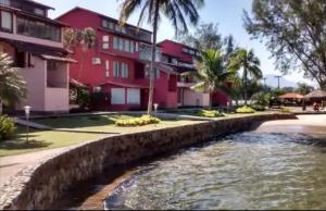 a river in front of a red building at Apartamento Angra dos Reis 1 in Angra dos Reis