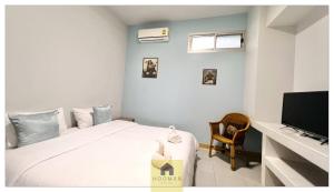 a bedroom with a bed and a television at Hooman Hostel in Chiang Mai