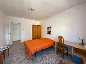 a bedroom with an orange bed and a desk at BIGGER FLAT IDEAL PARA FAMILIA NEAR CENTER AND BEACH in Valencia