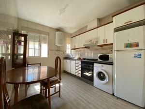 a kitchen with a table and a refrigerator and a dishwasher at BIGGER FLAT IDEAL PARA FAMILIA NEAR CENTER AND BEACH in Valencia