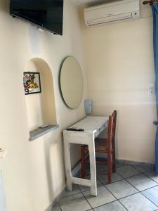 mały biały stół z lustrem i krzesłem w obiekcie Sea View Studios & Apartments w mieście Agia Anna (Naxos)