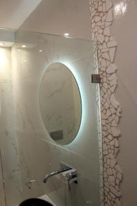 a bathroom with a mirror on a wall with a sink at Sea View Studios & Apartments in Agia Anna Naxos