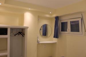 W łazience znajduje się umywalka i lustro. w obiekcie Sea View Studios & Apartments w mieście Agia Anna (Naxos)