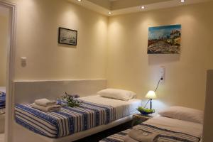 a bedroom with two beds and a painting on the wall at Sea View Studios & Apartments in Agia Anna Naxos