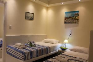 um quarto com duas camas e um quadro na parede em Sea View Studios & Apartments em Agia Anna (Naxos)