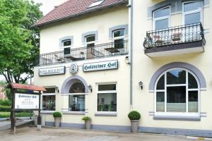 a white building with a sign on the side of it at Hotel-Restaurant Holsteiner Hof in Geesthacht