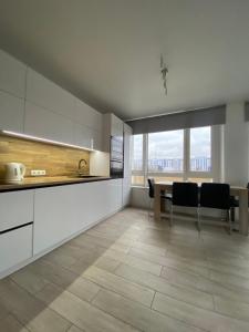 a kitchen with a table and chairs and a dining room at New 3 rooms apartment near the metro station in Kyiv