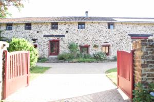 a stone house with a red gate and a driveway at LES 2 CHENES in Les Riffes