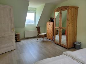 ein Schlafzimmer mit einer großen Holzkommode und einem Spiegel in der Unterkunft Anam Sona SeaView B&B in Caherkeen