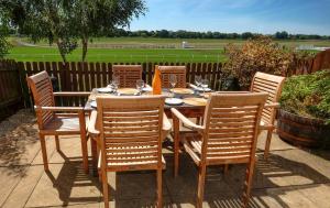 una mesa de madera con 6 sillas alrededor con una valla en Whole house, easy walk to town centre, Parking, Self Catering, Great View, 3 bedrooms, sleeps 6 en Stratford-upon-Avon