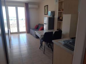 a kitchen and living room with a table and a refrigerator at Apartments Pehar in Zaostrog