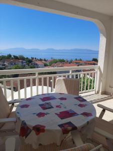 a table and chairs on a balcony with a view of the ocean at Apartments Pehar in Zaostrog